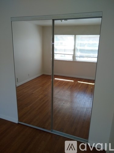 A room with a sliding glass door and wooden flooring.
