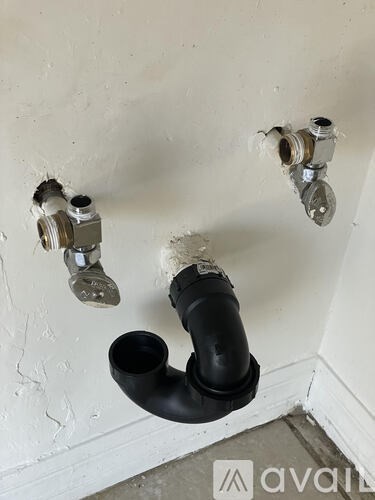 Three pipes are attached to a wall.