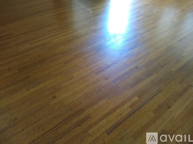 A wooden floor with a light source reflecting off it.