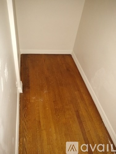 A room with wooden flooring and white walls.