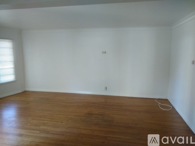 Empty room with wooden floor and white walls.