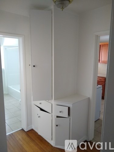 A white cupboard with a drawer is in a room.