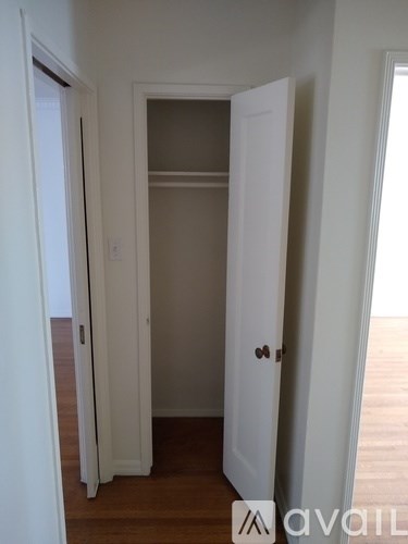 A white door is open to a small, empty room.