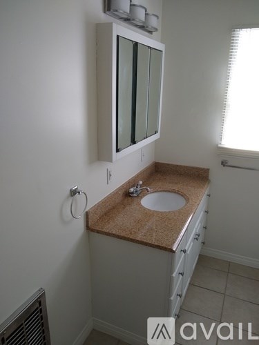 A bathroom with a sink and a mirror above it.