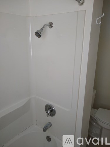 A white bathroom with a tub and toilet.