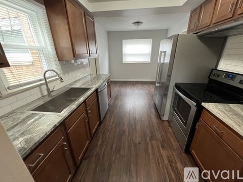 A kitchen with wooden cabinets and a marble countertop.