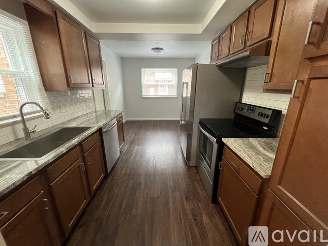 A kitchen with wooden cabinets and a stainless steel refrigerator.