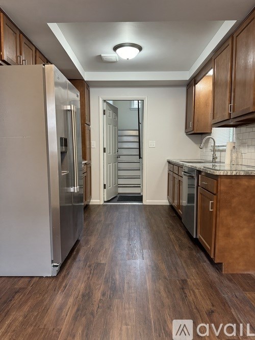 A kitchen with wooden cabinets and a refrigerator.