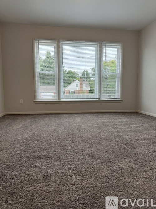 A room with a carpeted floor and a large window.