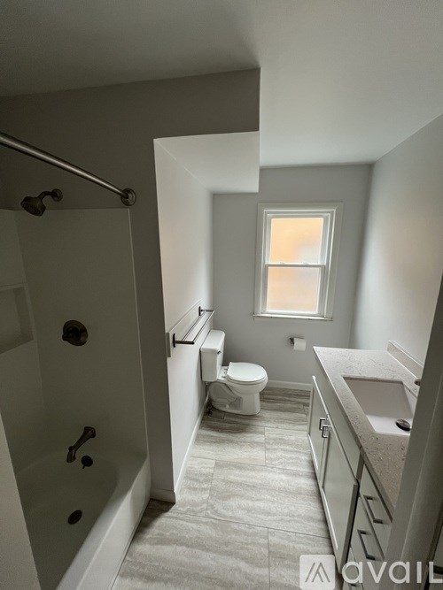 A bathroom with a tub, toilet, and sink.
