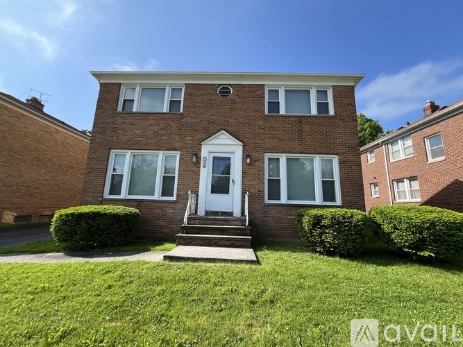 A brick house with a white door and windows.