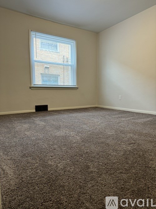 A room with a carpeted floor and a window.