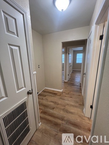 A hallway with a white door and a light on the ceiling.