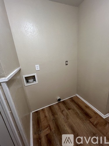 A room with a wooden floor and a white wall.