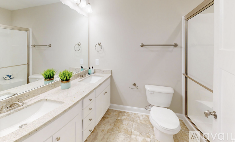 A white bathroom with a toilet, sink, and mirror.