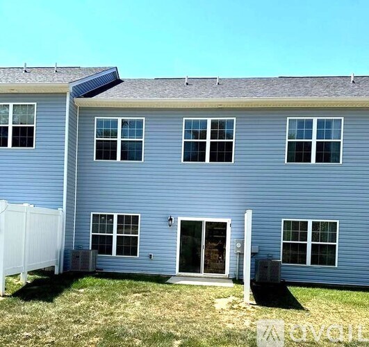 A blue house with a white fence and a black door.