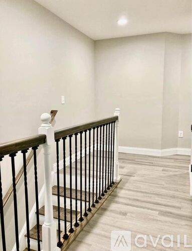 A staircase with a black railing and wooden steps.