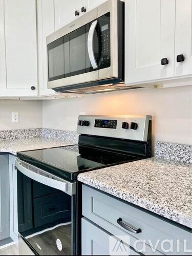 A kitchen with a black oven and microwave above it.