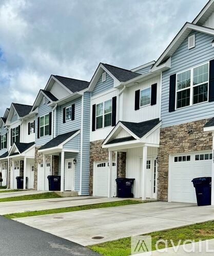 A row of houses with garages and driveways.