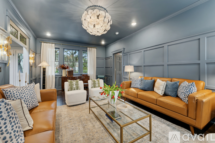 A living room with a brown leather couch and a glass coffee table.