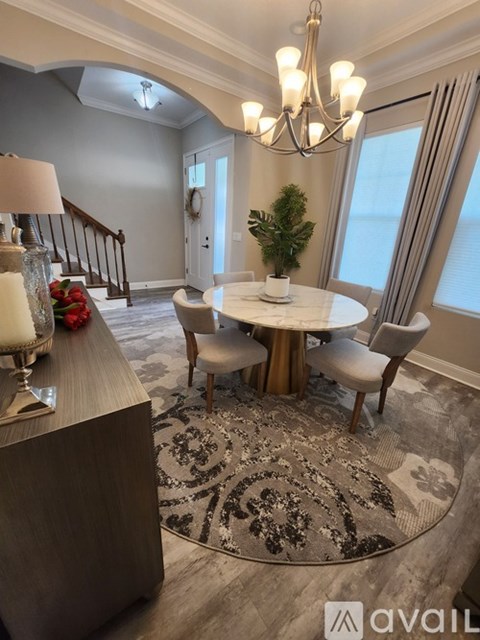 A well-lit dining room with a round table and chairs.