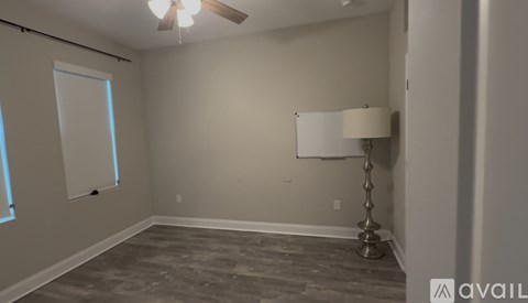 A room with a ceiling fan and a floor lamp.