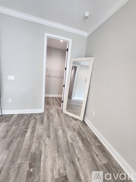 A room with a grey floor and a white door.