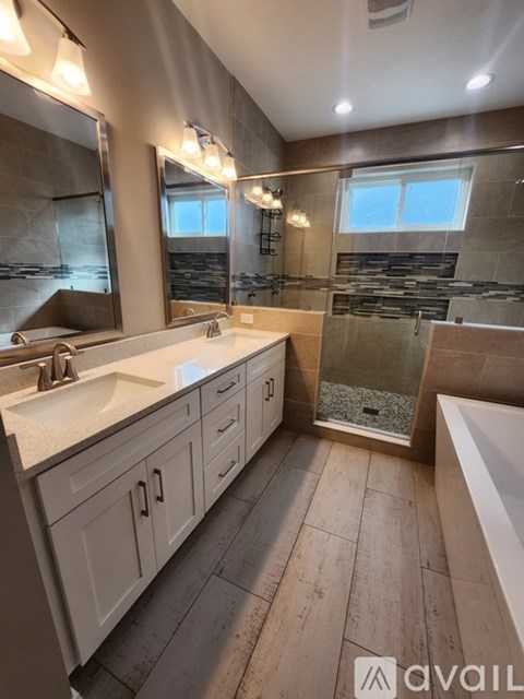 A bathroom with a sink, mirror, and a bathtub.