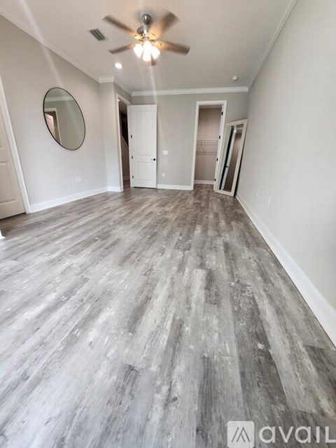 A room with a wooden floor and a ceiling fan.
