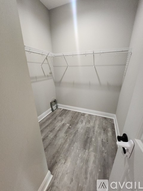 A room with a grey floor and a white wall with a shelf on it.
