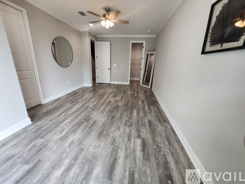A room with a wooden floor and a ceiling fan.
