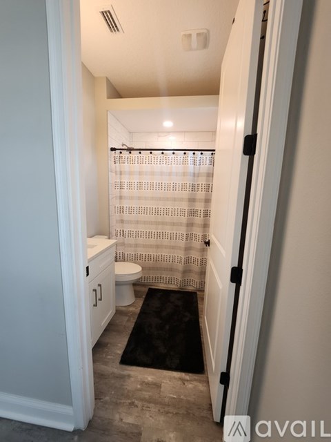 A bathroom with a toilet, sink and shower.