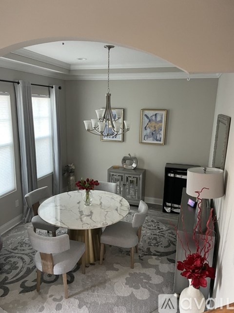 A dining room with a round table and chairs.