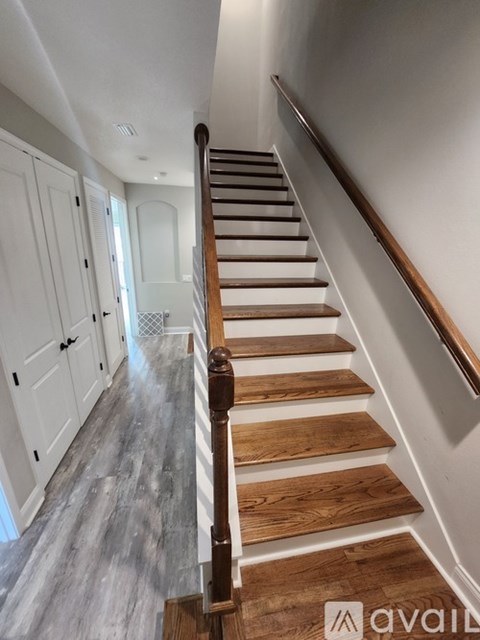 A wooden staircase with a white wall on the side.