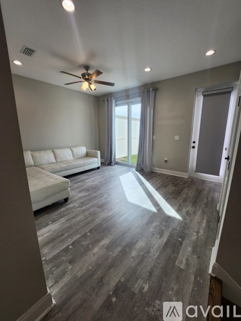 A living room with a white couch and a ceiling fan.