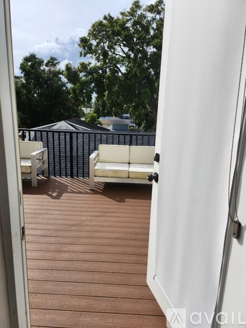 A balcony with a white chair and a white door.