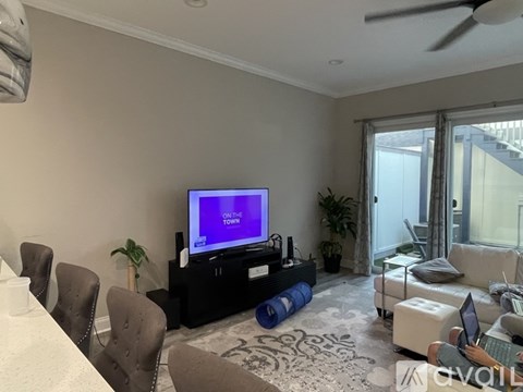 A living room with a television displaying the words "ON THE TOWN" on a purple screen.