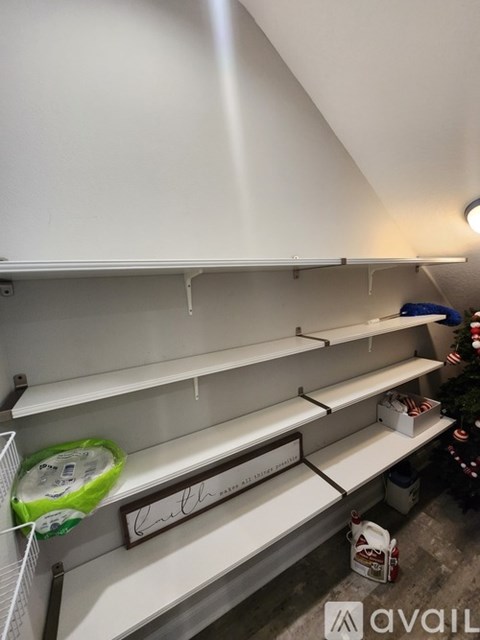 A balcony with a chair and a table is shown with the sun shining through the trees.