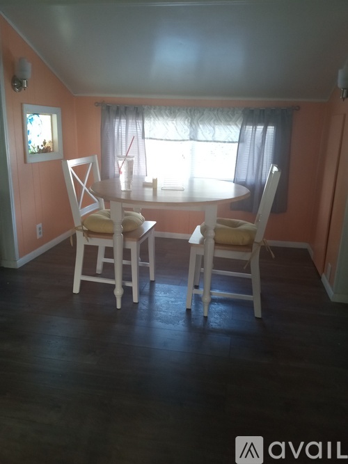 A dining room with a table and chairs.