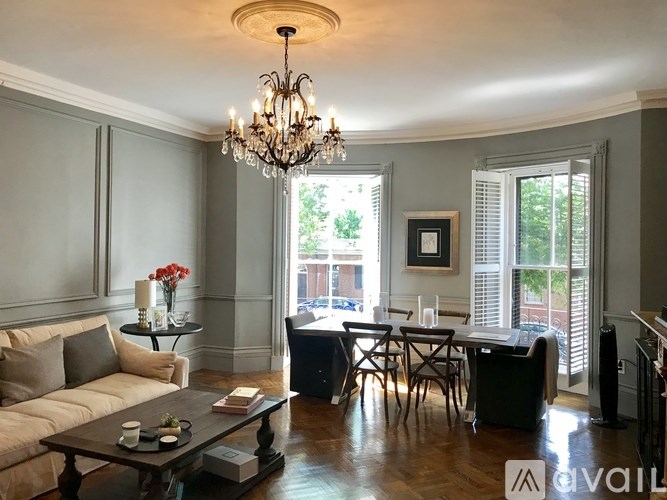 A living room with a couch, chairs, and a dining table.