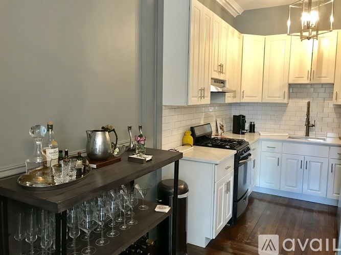 A kitchen with a black countertop and white cabinets.