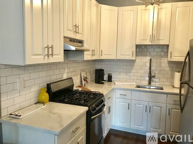 A kitchen with white cabinets and a black stove top.