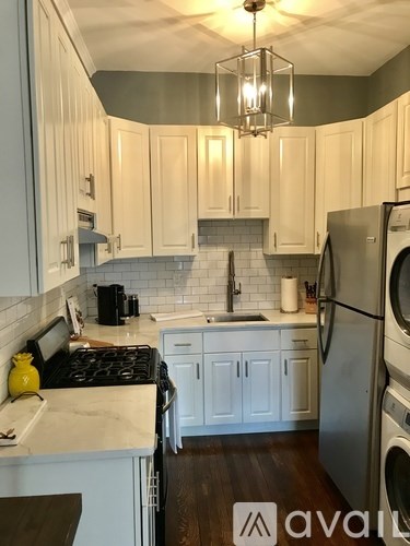 A kitchen with white cabinets and a black stove top.
