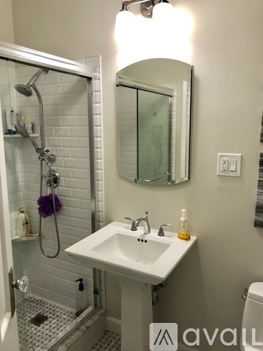 A bathroom with a white sink and a mirror above it.