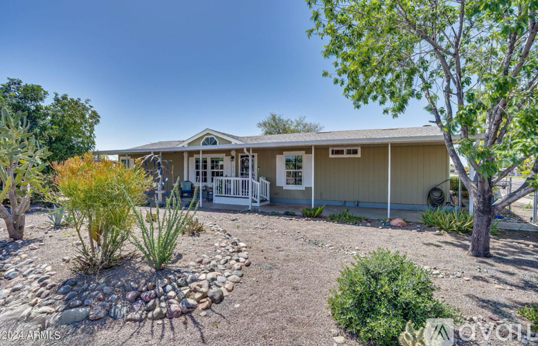 A house with a front yard and a white fence.