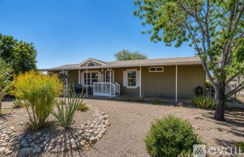 A house with a front yard and a white fence.
