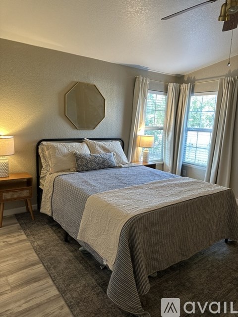 A bedroom with a bed, nightstand, and window.