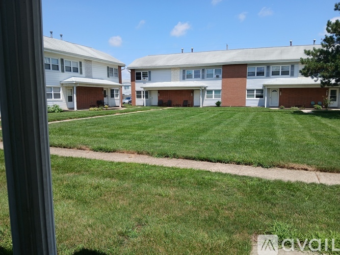 A grassy area in front of a building with a clear blue sky.