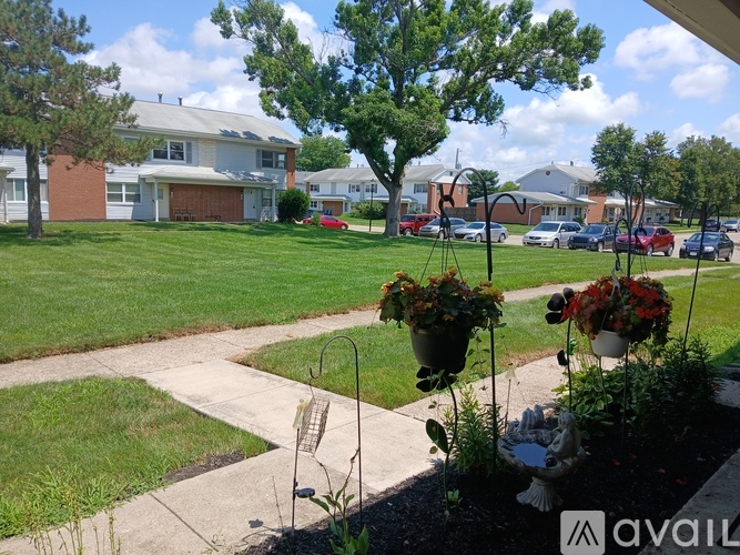 A residential area with houses, cars, and greenery.