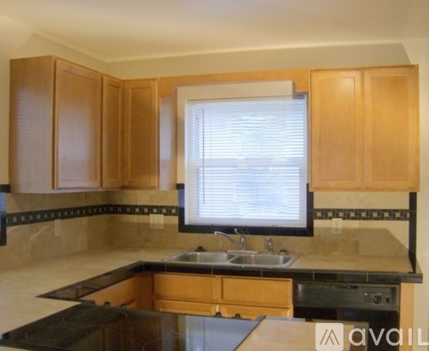 A kitchen with wooden cabinets and a black countertop.